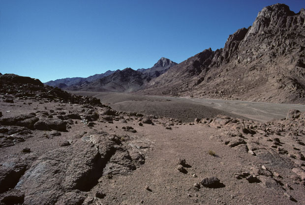 Mount Sinai, height 2382m, also called Mt Horeb in the scriptures, seen upper mid-picture in a south-westward view from the rock-strewn plain of Wadi es Sadad about 2 kilometers north of its junction with Wadi Sebaiyeh. The closer, darker mountain to the left of Mt Sinai is Jebel el Muneijah, height 1825m, believed by some to be the true Mt Moses, or Jebel Musa, where the Law was given. 