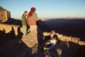Visitor and Bedouin guides in walled area, including Christian Chapel (left-picture), on summit of Mt Sinai at sunset.