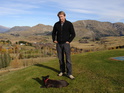 Sam Neill, Kiwi actor and winegrower, in Autumn 2005 at his Queenstown home property near the Shotover River, Central Otago, casually, albeit quizzically, eyes the photographer. Sam's red-collared black dog, looking South in the direction of the famous Remarkables mountain range nearby, appears somewhat less interested in the goings-on than does his Master.