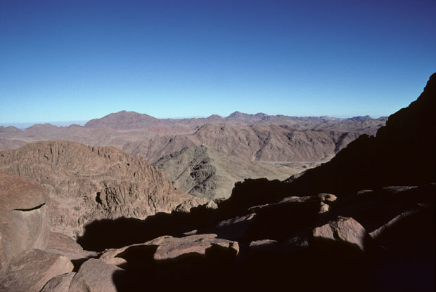 View to the east, from above the level of Elijah's Basin, on the Steps of Repentance, the most popular route for visitors climbing Mt Sinai from St Catherine's Monastery in Wadi ed-Deir. The grey mountain seen centre picture and topped by a small white structure (a church dedicated to two Roman soldier Christian martyrs) is Gebel el Muneiyah which is shown in westward views, from Wadi es Sadad, by images 1 to 12.    