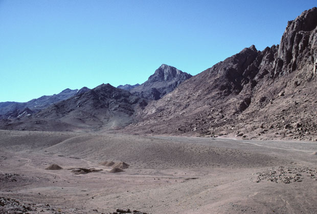 Mount Sinai, height 2382m, also called Mt Horeb in the scriptures, seen upper mid-picture in this south-westward view from Wadi es Sadad about 2 kilometers north of its junction with Wadi Sebaiyeh. The closer, darker mountain see here to the left of Mt Sinai is Jebel el Muneijah, height 1825m, believed by some to be the true Mt Moses, or Jebel Musa, where the Law was given. 
