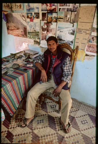 The charming, gentle and wonderfully competent Bedouin Hakim (doctor) Jordan Hamdi, administrator and guide as well as our superb host and hands-on healer at Faraj Fox Camp, near St Katarina Tourist Village, on our November 2004 visit to Mt Sinai. For this portrait he sat in the Office chair, surrounded by maps and photographs of the area as well as from other important places including, of course, Mecca and Jerusalem.Technical data: camera, Canon F1; lens, L-series Canon 20-35mm; film, Kodachrome II; exposure, 1/8th second at f/3.5. No filter.Transparency scanned to digital file using Nikon 50 Coolpic 35mm scanner.