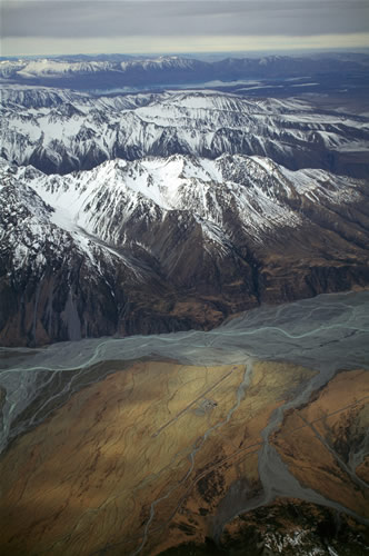 Tasman Glacier Valley: Mt Cook Airport building and airstrip in mid-upper foreground; Burnett mountains in midground; Lake Tekapo at foot of most distant mountain range.