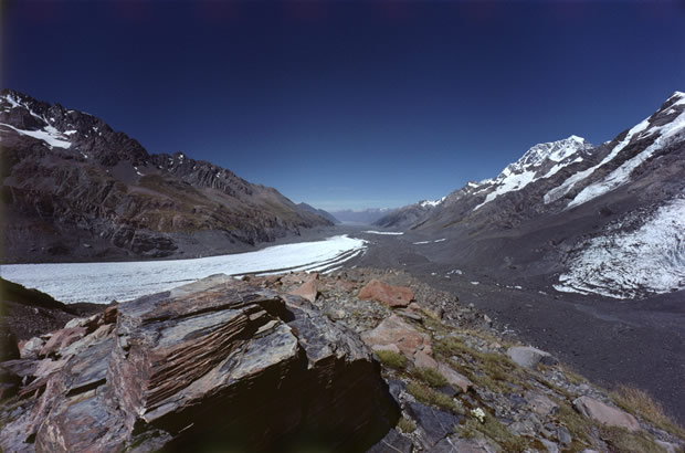 Tasman Glacier (left) converging with Rudolph Glacier (right). Southward view from the rock-covered De La Beche ridge (see also image 26) which separates the two glaciers here. Mt Cook, mid-right, in distance.