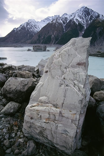 North-eastward view of lower part of Tasman Glacier. Naturally sculptured rock slab being transported south on median moraine. Malte Brun range in background.