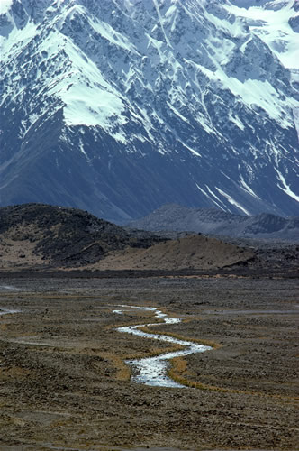 Tasman Glacier Valley in summer: Tributary of Tasman River south of vegetation-covered terminal moraine. Grey lateral moraine and Liebig range in background.