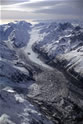 Northward view of the Tasman Glacier showing rock debris spilt down the Hochstetter Glacier (entering lower left) from the 1991 rock avalanche from the east side of the high peak of Mt Cook. The avalanche was estimated to total 10 million cubic metres and reduced the height of the mountain by 10 metres. Upper-left picture, the Rudolf Glacier enters the Tasman. 